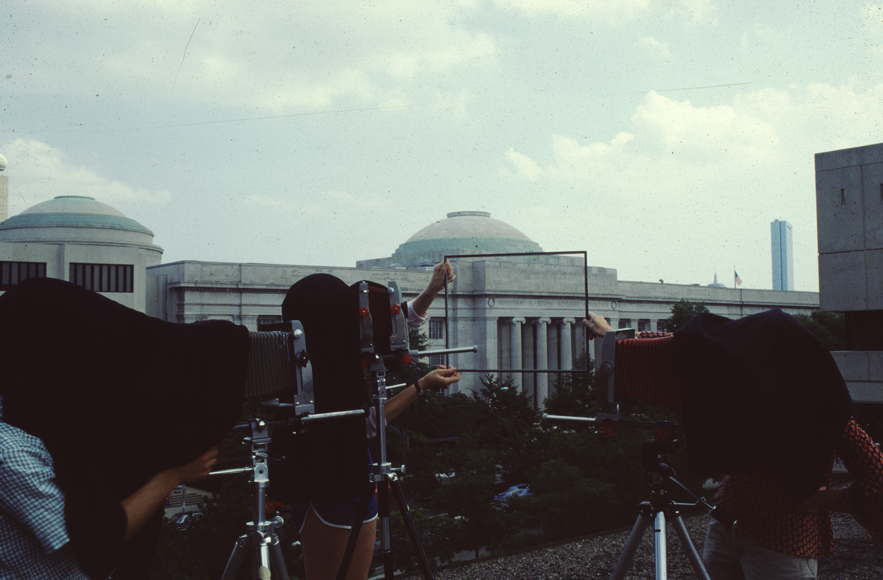 Archival photo of a group of students using photography equipment in front of MIT's Great Dome